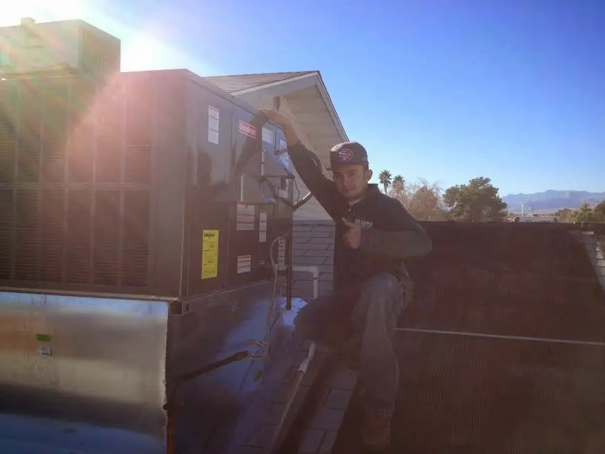 HVAC technician performing AC Tune-Up on a rooftop unit in Pilot Point